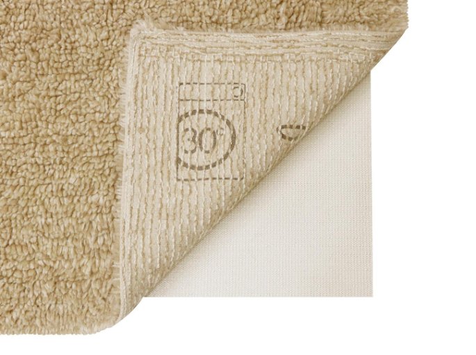 Envers clair d'une carpette beige retournée, étiquette de lavage à 30 degrés visible