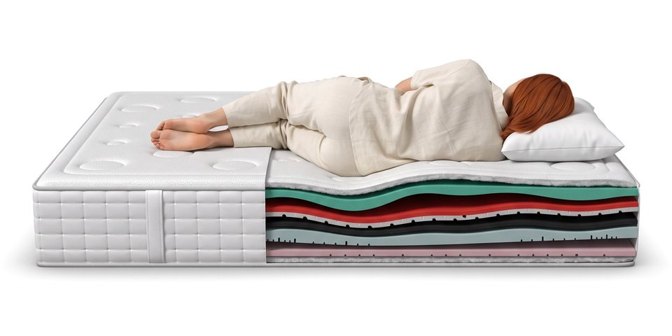 Coupe du matelas Canopée sous une dormeuse allongée sur le côté