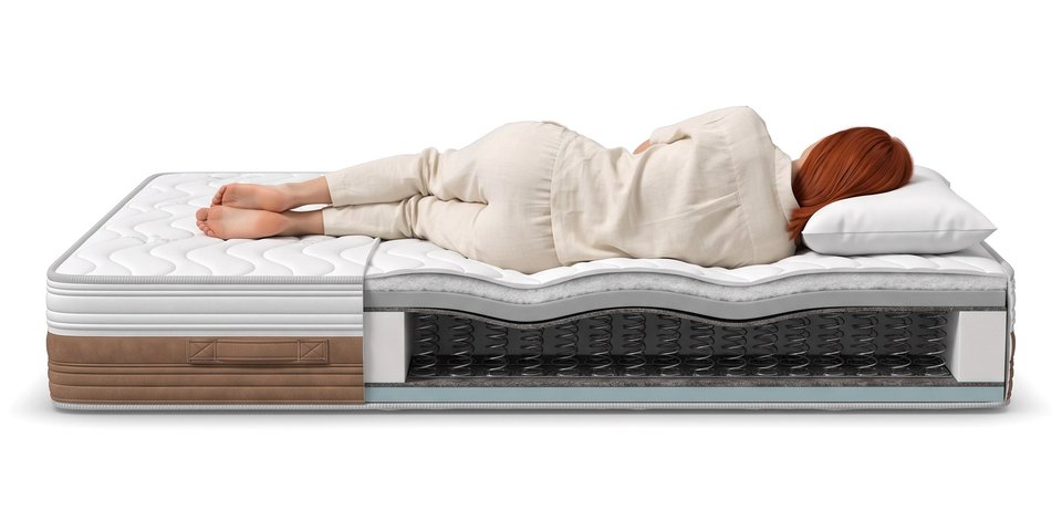 Coupe du matelas Falaise sous une dormeuse allongée sur le côté