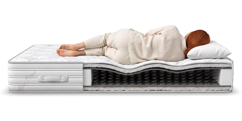 Coupe du matelas Rempart sous une dormeuse allongée sur le côté